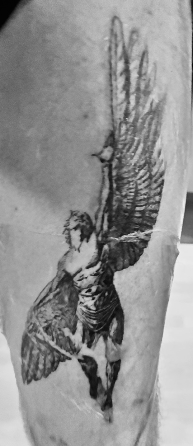 Black and grey realism tattoo of a winged warrior figure on a thigh
